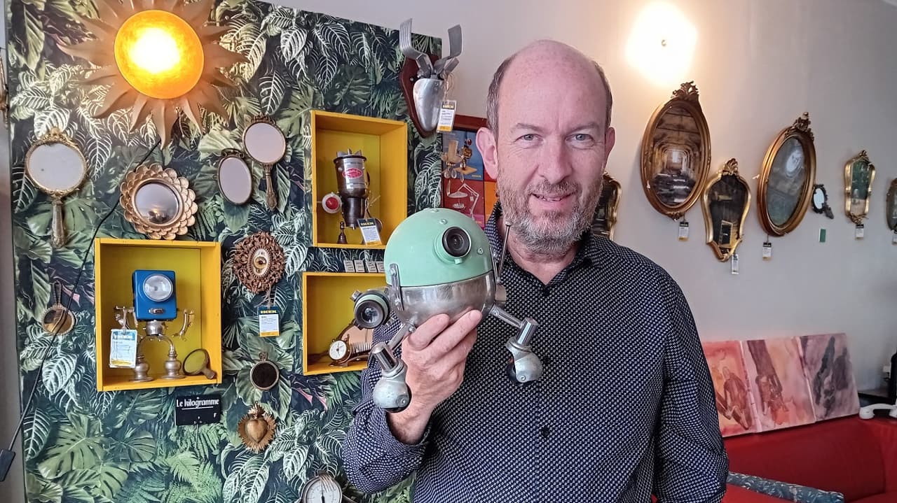 Dominique Hermier dans sa galerie-boutique de Blois, tenant un robot assemblé à partir d'objets récupérés